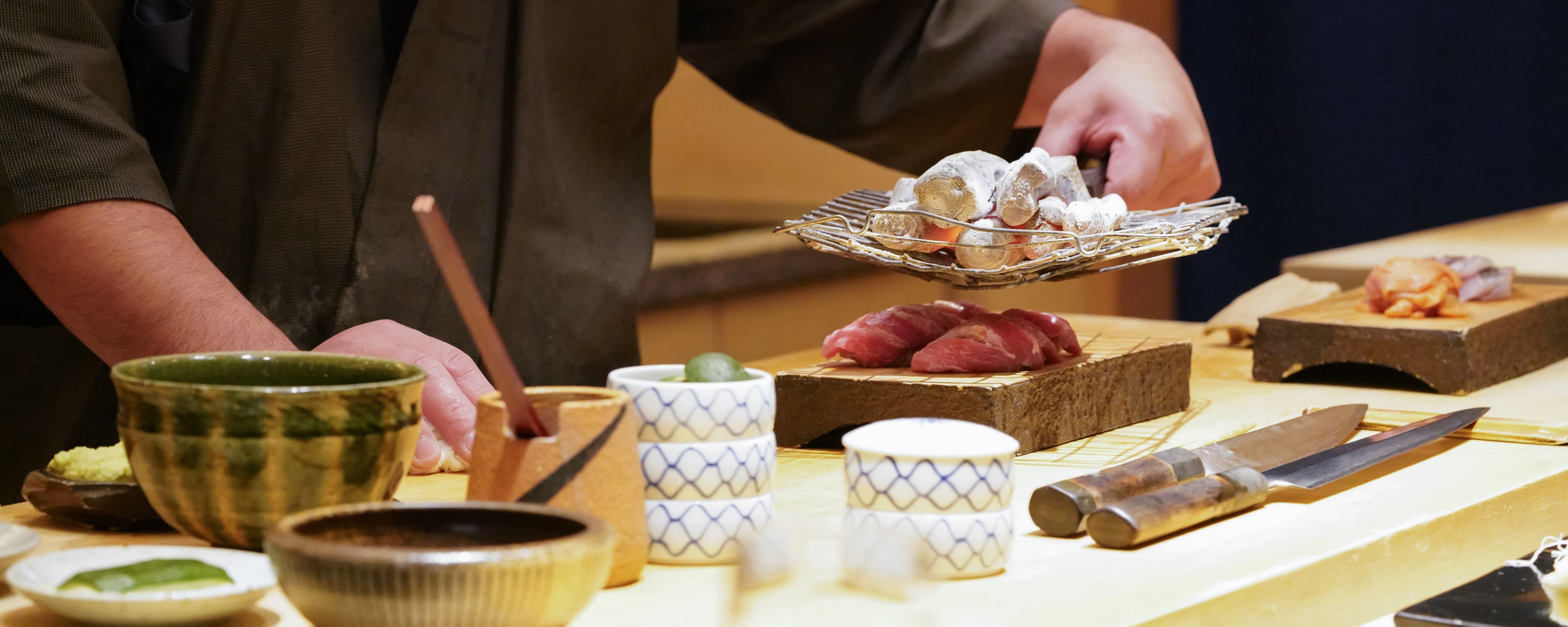 Chef plating a course at the omakase counter