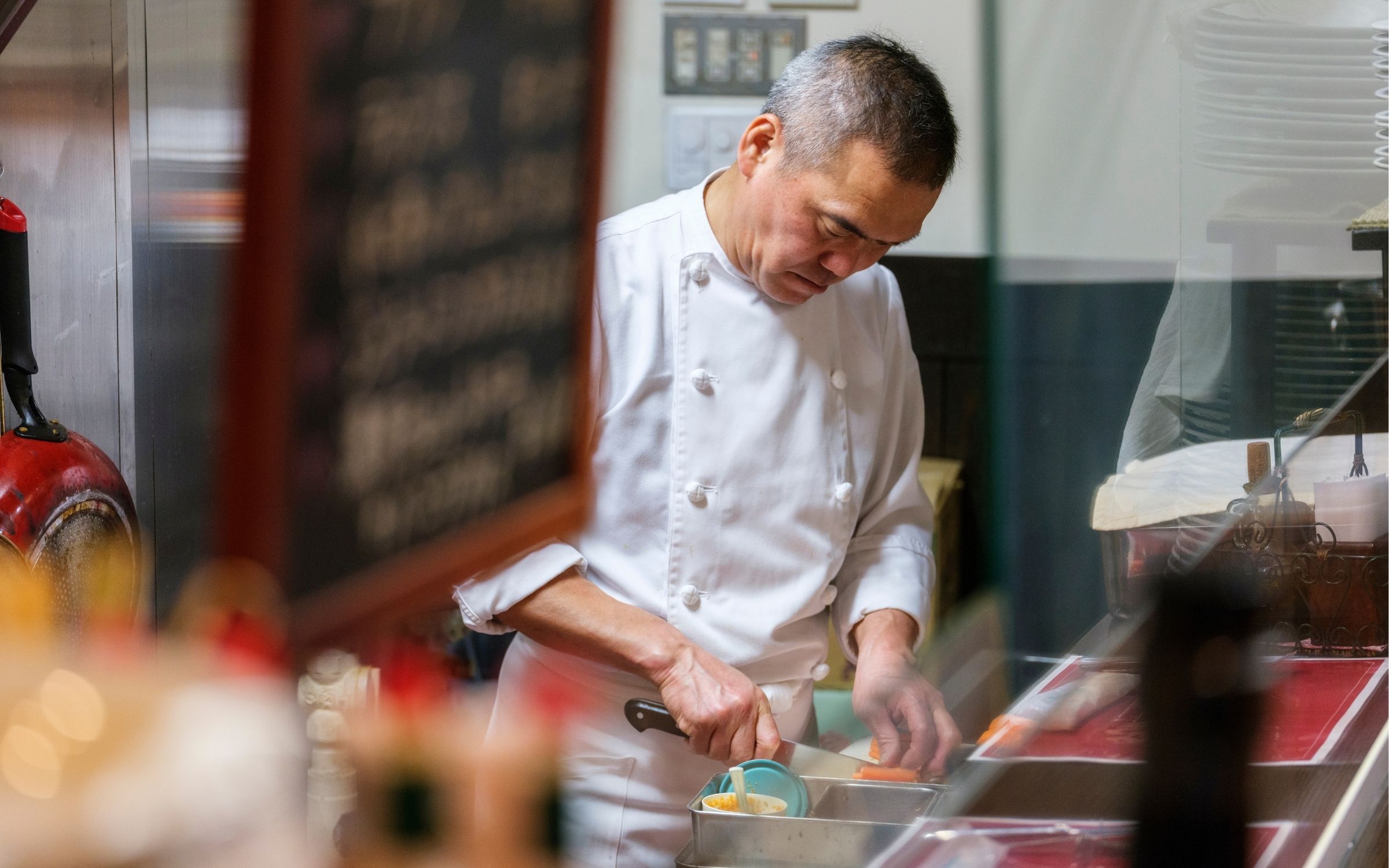 Chef Kenji Arata slicing fish at the counter